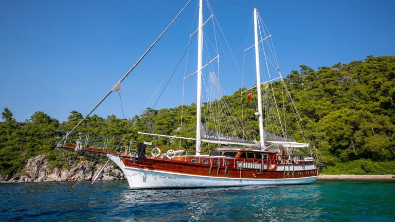 Chartered gulet is waiting in a quiet bay for its next voyage on the blue sea.